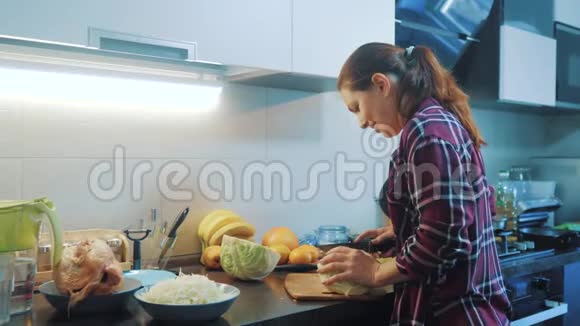厨房里的女人在准备生活方式一顿饭的概念厨房里的女孩用刀切卷心菜做素食者视频的预览图