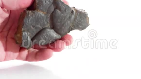 金属陨石在手白色背景视频的预览图