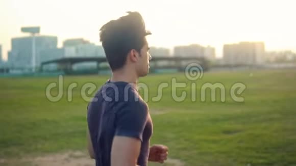 年轻人在公园里奔跑背景是摩天大楼视频的预览图