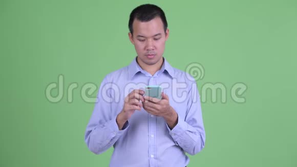 快乐的亚洲商人用电话视频的预览图