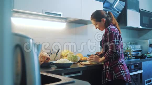 女人在厨房的生活方式准备一顿饭的概念厨房里的女孩用刀切卷心菜做素食者视频的预览图