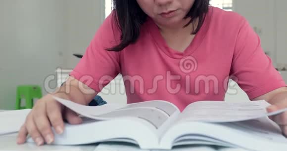 年轻的亚洲女性阅读写作和谈话的概念视频的预览图