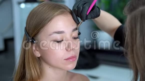 年轻美容师白种人女孩举着模特修眉视频的预览图
