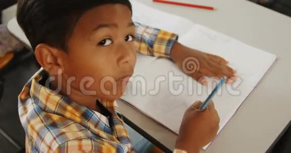 坐在教室里书桌旁的男孩的肖像视频的预览图