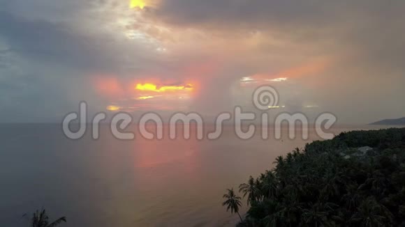 日出期间从无人驾驶飞机在海上俯瞰海滨海滩棕榈树印度尼西亚巴厘岛视频的预览图