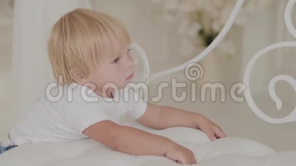 美丽快乐的小男孩正在白色的房间里玩耍视频的预览图