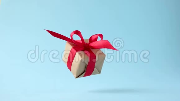 礼品盒红色丝带在蓝色背景上旋转360度旋转无缝环零重力悬浮概念销售视频的预览图
