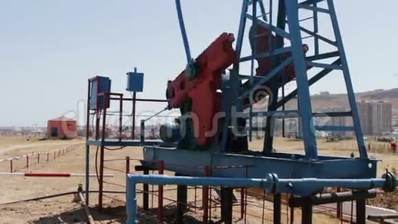 阿塞拜疆巴库一个工作油田的一部分油井工作油泵和一个生锈的旧铁的剪影视频的预览图