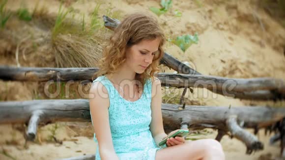 一个忙碌的年轻女子正在用一台手提电脑手里拿着商业文件拿起一个电话坐着打电话视频的预览图