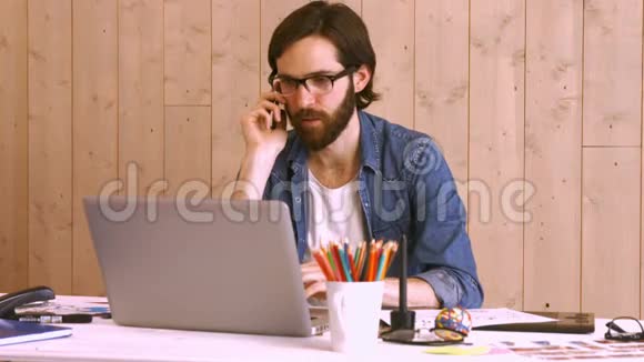办公桌旁的临时工作人员使用笔记本电脑视频的预览图