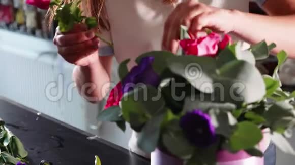 花艺女郎在花艺沙龙做花盒特写视频的预览图