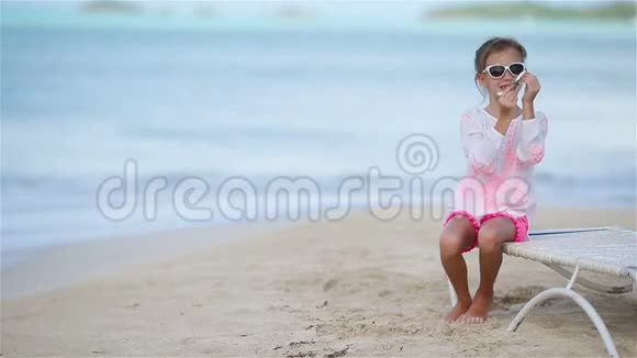 快乐的小女孩手里拿着玩具飞机在白色沙滩上小孩在海滩上玩玩具视频的预览图