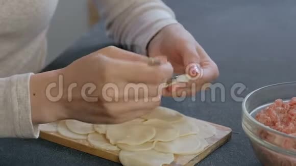 女人用肉馅包饺子特写的手视频的预览图