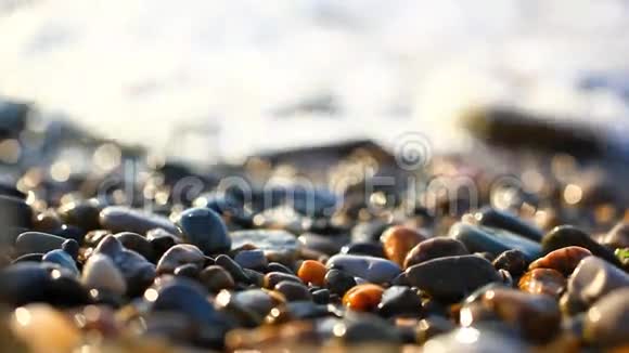 在令人惊叹的日落中海滩上五颜六色的鹅卵石视频的预览图