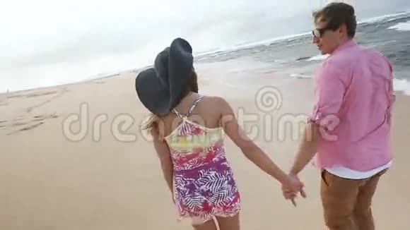 可爱的白种人年轻夫妇牵着手在夏威夷瓦胡岛海滩散步视频的预览图