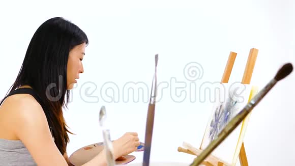 画架上的亚洲艺术家绘画视频的预览图