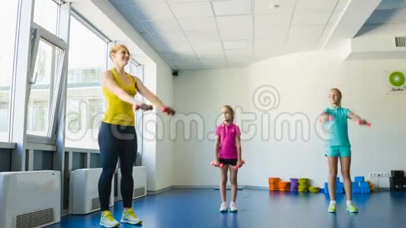 在健身课上做体操的女生和指导员或妈妈视频的预览图