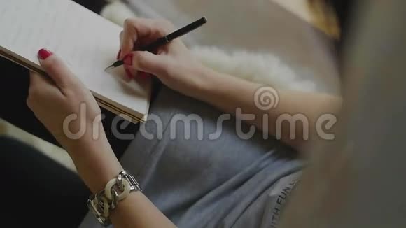 女性用笔在记事本上写字视频的预览图