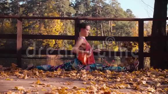 在公园桥上做舞蹈练习的女人视频的预览图