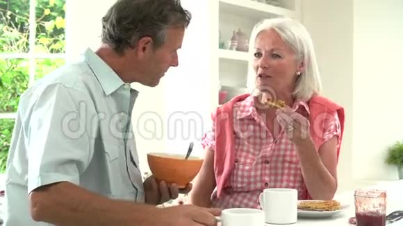 中老年夫妇在厨房一起吃早餐视频的预览图