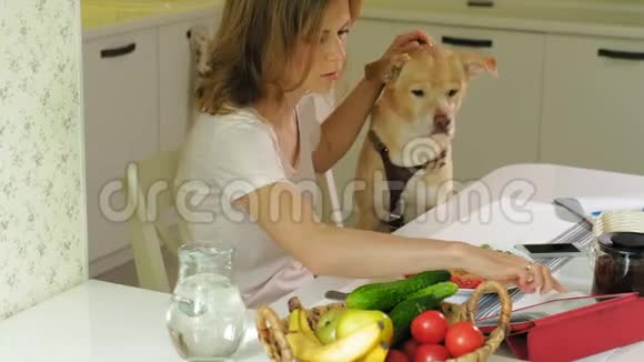 在餐桌前厨房里有只狗的女人早餐人与宠物的友谊视频的预览图