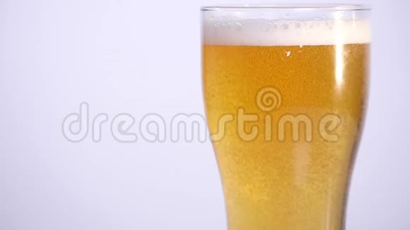 一杯啤酒倒在白色背景上近点视频的预览图