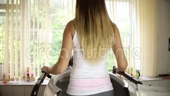 年轻女子参加体育运动在健身房健身女孩在模拟器上做运动视频的预览图