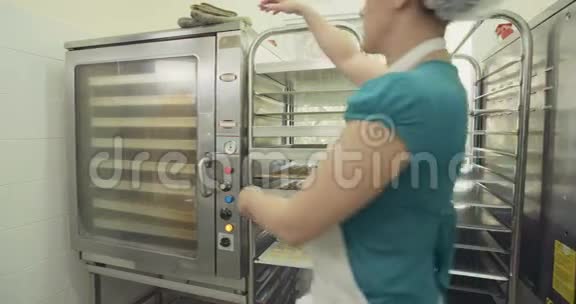 面包师把饼干放在烤箱里视频的预览图