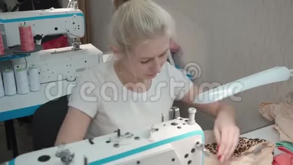 女裁缝在车间电机上缝制衣服视频的预览图