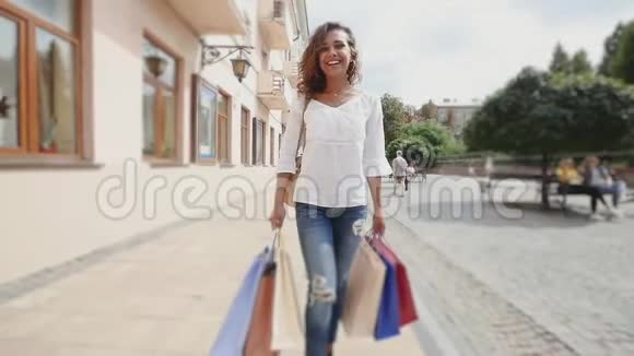 城里有购物袋的快乐女人慢动作视频的预览图
