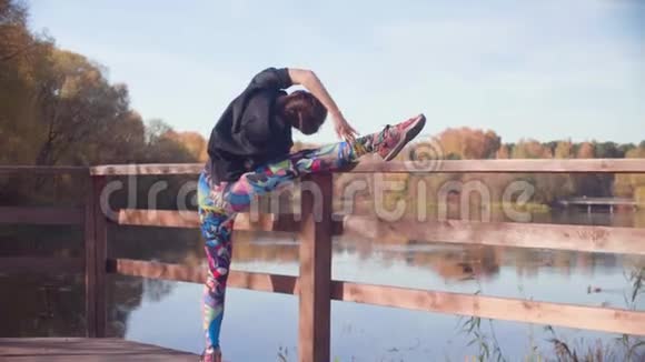在公园桥上做舞蹈练习的女人视频的预览图
