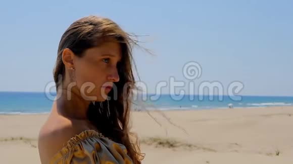 站在海边沙丘上的年轻美女视频的预览图