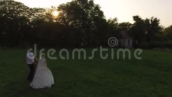 鸟瞰日落时美丽的新婚夫妇4k视频的预览图