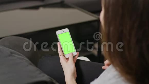 女士手持蓝屏智能手机视频的预览图