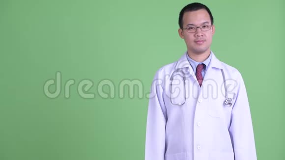 快乐的亚洲男子医生展示了一些东西视频的预览图