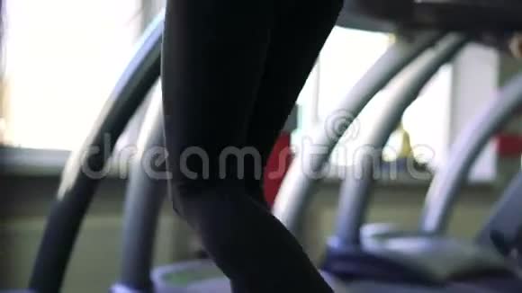 一个女孩在跑步机上的特写4k视频的预览图