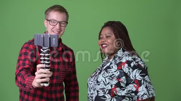 超重的非洲妇女和年轻的斯堪的纳维亚男人在绿色背景下在一起视频的预览图