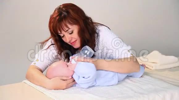 妈妈正在给婴儿喂一瓶爱的牛奶视频的预览图