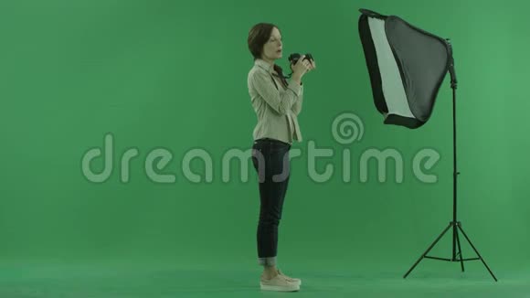 一位年轻女子在绿色屏幕的右手边拍照视频的预览图