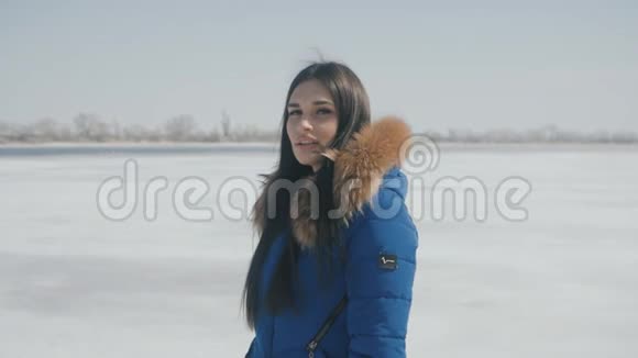 一幅年轻美丽的黑发女子冬天在雪地上的肖像视频的预览图