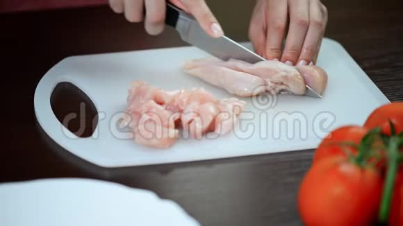 女人在桌上割鸡胸肉视频的预览图