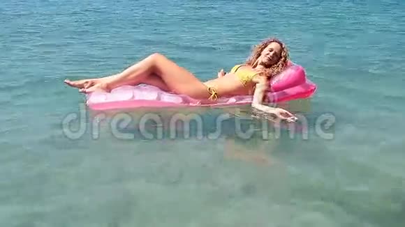 小女孩漂浮在海中的床垫上视频的预览图