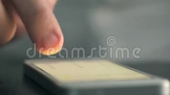 桌上的移动电话用手指刷洗视频的预览图