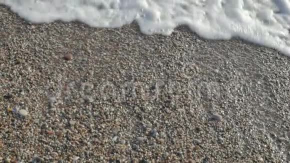 海滩上的波浪和泡沫海边的卵石视频的预览图