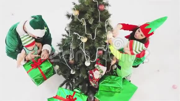 幸福的家庭装饰圣诞树穿着精灵服装视频的预览图