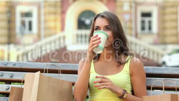 坐在长椅上喝咖啡的女孩视频的预览图