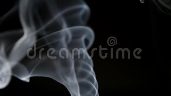 缓慢移动优雅的曲线烟雾在黑暗的背景上升起视频的预览图