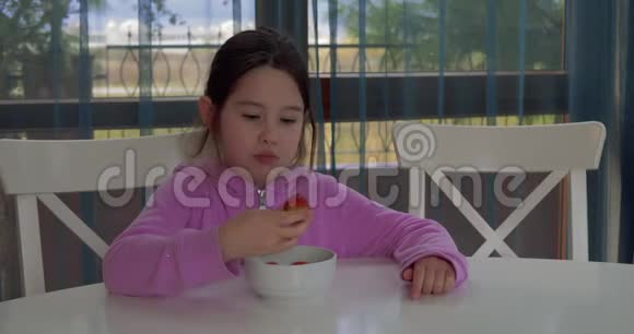 快乐的小女孩在家吃草莓视频的预览图
