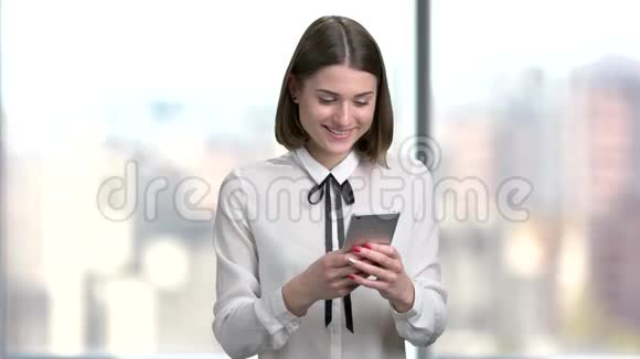 年轻微笑的女人用智能手机视频的预览图