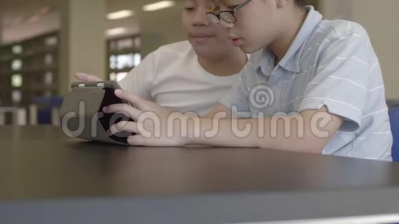 两个男孩微笑着在平板电脑上画画视频的预览图